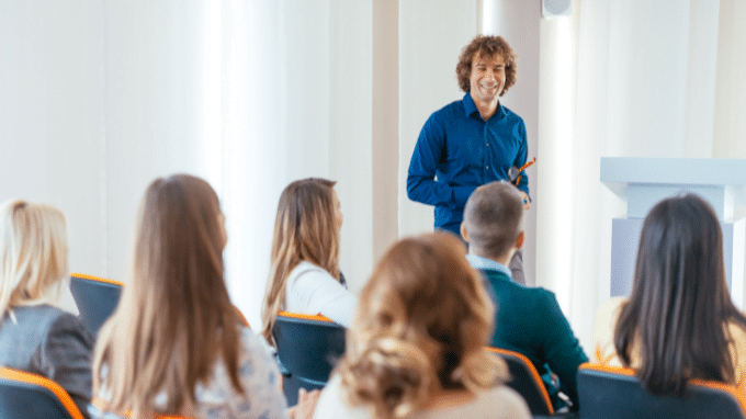 A handsome male mental health coach is talking to his students.